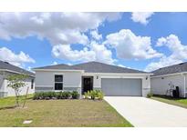 Well-maintained home features a two-car garage and manicured lawn at 1241 Denali Dr, Winter Haven, FL 33881