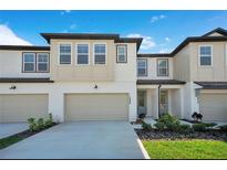 Charming townhome featuring a two-car garage and modern architectural details at 1868 Sanibel Dr, Davenport, FL 33896