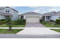 Charming single-Gathering home featuring a two-car garage and well-maintained landscaping at 1872 Summer Serenity Dr, Kissimmee, FL 34744