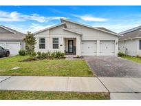 Charming single-story home with a well-manicured lawn and attached two-car garage at 18863 Rawson St, Orlando, FL 32827