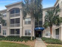 Three-story condo building with a blue awning over the entrance and several palm trees on the property at 3300 Whitestone Cir # 201, Kissimmee, FL 34741