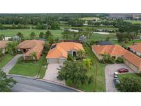 Lovely aerial view of a home with terra cotta roof, an attached two-car garage, and a beautifully landscaped yard at 133 Torino Ln, Kissimmee, FL 34759
