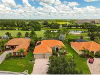 Beautiful aerial view of the homes with tile roofs, landscaping, and golf course at 133 Torino Ln, Kissimmee, FL 34759