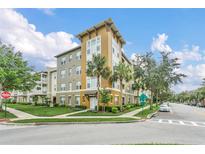 Beautiful condominium complex with lush green lawns, mature trees, and sidewalks for a walkable community at 1411 Celebration Ave # 106, Celebration, FL 34747