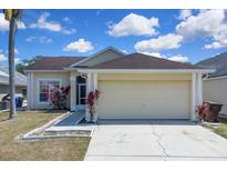 Charming single-story home featuring a two-car garage and colorful landscaping at 2049 Shannon Lakes Blvd, Kissimmee, FL 34743