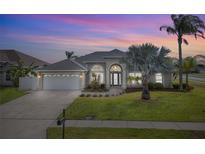 Charming home with arched entryway, well-manicured lawn, and lush palm trees at 3037 Diamond Ln, St Cloud, FL 34772