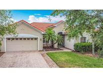 Charming single-Gathering home featuring a terra cotta roof, a brick driveway, and manicured landscaping at 4117 Navigator Way, Kissimmee, FL 34746