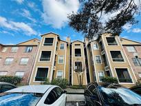 Lovely exterior view of apartments showcasing beige siding, trimmed windows, and a manicured landscape against a blue sky at 4301 Lizshire Ln # 308, Orlando, FL 32822