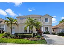 Charming two-story home featuring lush landscaping, palm trees, and a well-manicured lawn at 615 Copeland Dr, Haines City, FL 33844