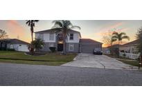 Charming two-story home with a well-maintained yard and mature palm trees, featuring a spacious driveway and attached garage at 773 Leopard Ct, Kissimmee, FL 34759