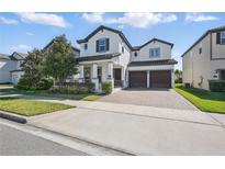 Beautiful two-story home featuring a two-car garage, well-manicured lawn, and tasteful landscaping at 12755 Westside Village Loop, Windermere, FL 34786