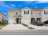 Inviting two-story townhome with attached garages and well-maintained landscaping at 208 Feltrim Reserve Blvd, Davenport, FL 33837
