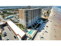Stunning aerial view of a beachfront high-rise with pools and a beautiful sandy beach at 2403 S Atlantic Ave # 501, Daytona Beach Shores, FL 32118