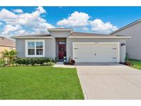 Charming single-story home featuring a two-car garage, well-manicured lawn, and inviting front entrance at 2874 Turnstone Run, Harmony, FL 34773