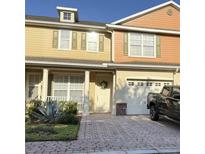 Charming two-story home featuring a well-manicured front yard, brick paved driveway, and attached garage at 3561 Sanctuary Dr, St Cloud, FL 34769