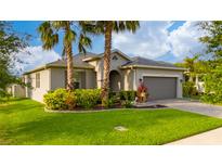 Charming single-story home with a well-manicured lawn, lush landscaping, and a two-car garage at 4007 Green Sabal Dr, Orlando, FL 32824