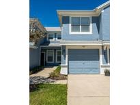 A charming two-story home features a light blue exterior, attached garage, and well-maintained landscaping at 4525 Sw 52Nd Cir # 103, Ocala, FL 34474