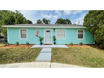 Charming single-story home featuring a vibrant turquoise exterior and well-maintained front yard at 4765 Lake Shore Dr, St Cloud, FL 34772
