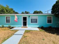 Charming, light blue single-story home featuring a welcoming entrance and well-maintained front yard under a clear blue sky at 4765 Lake Shore Dr, St Cloud, FL 34772