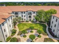 Stunning aerial view of condo complex showcasing lush courtyard and Spanish tile roof at 5550 E Michigan St # 2214, Orlando, FL 32822