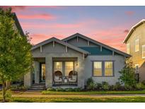 Charming single-Gathering home features a covered porch with stylish seating and a well-manicured lawn at 8338 Modiano St, Orlando, FL 32827