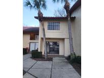 Inviting townhouse exterior featuring lush palm trees and a tiled roof, near a paved walkway at 10330 Turkey Lake Rd # A-4 Ak/A 107, Orlando, FL 32819