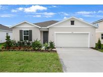 Charming single-story home boasts a manicured lawn and an attached two-car garage at 1126 Olivine Ave, Dundee, FL 33838