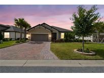 Charming single-story home features a brick driveway, two-car garage, and well-manicured lawn at 204 Bella Cortina Dr, Poinciana, FL 34759
