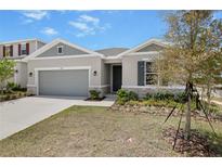 Charming single-story home with a two-car garage, stone accents, and well-maintained landscaping at 1654 Sugarbelle Cir, Mascotte, FL 34753