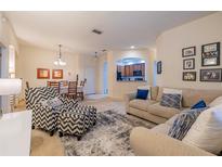 Inviting living room featuring modern furniture, neutral tones, and a view into the adjacent dining area and kitchen at 3301 Whitestone Cir # 203, Kissimmee, FL 34741