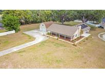Charming home with a long driveway, detached garage, covered porch, and ample front yard space at 7938 Riffle Ln, Orlando, FL 32818
