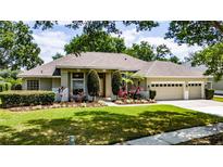 Charming ranch-style home featuring a three-car garage and mature landscaping for enhanced curb appeal at 9509 Baycliff Ct, Orlando, FL 32836