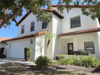 Beautiful two-story home with red tile roof, manicured landscaping, and an attached two car garage at 141 Summer Place Loop, Clermont, FL 34714