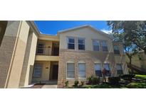 Inviting multi-level condo featuring a mix of neutral colors and well-maintained landscaping under a clear blue sky at 2804 Club Cortile Cir # A, Kissimmee, FL 34746