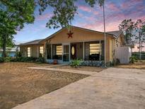 Charming single-story home with a screen porch, mature landscaping, and a spacious front yard at 629 N 7Th St, Lake Wales, FL 33853