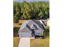 Charming single Gathering home with gray roof, lush green front yard, and convenient two car garage at 3633 Bristol Cove Ln, St Cloud, FL 34772