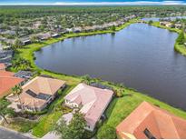 Stunning lakefront property with lush landscaping, mature trees, and terra cotta tile roof in a beautiful lakeside community at 644 Shorehaven Dr, Kissimmee, FL 34759