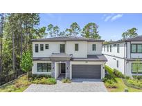 Beautiful two-story home featuring manicured landscaping, a two-car garage, and a stone-accented entrance at 1326 Butterfly Orchid Rd, Davenport, FL 33837