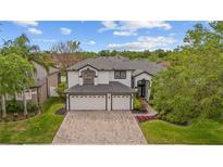 Stunning two-story home showcasing a brick driveway and a manicured lawn at 1559 Wescott Loop, Winter Springs, FL 32708