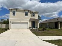 Charming two-story home with a two-car garage and a well-maintained front yard at 1723 Post Oak Dr, Davenport, FL 33837