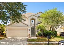 Charming two-story home with a well-manicured lawn and attached two-car garage at 206 Bonville Dr, Davenport, FL 33897