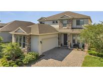 Charming two-story home featuring stone accents, a spacious garage, and a beautifully paved driveway at 2348 Pearl Cider St, Orlando, FL 32824