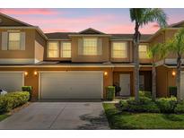 Charming two-story townhouse featuring a large garage and well-manicured landscaping at 3610 Rodrick Cir, Orlando, FL 32824