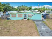 Charming single story home featuring a tidy front yard, paved driveway, and unique sky blue exterior at 690 W Pearl St, Bartow, FL 33830