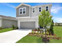 Beautiful two-story home featuring a modern gray and white color scheme and manicured landscaping at 824 Lake Dell Rd, Dundee, FL 33838