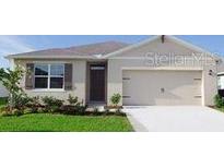 Charming single-story home with a well-manicured lawn, attached garage and inviting front entrance at 1104 Star Ruby Ln, Winter Haven, FL 33880