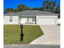 Charming single-story home featuring a well-manicured lawn and a two-car garage on a sunny day at 15954 Sw 55Th Avenue Rd, Ocala, FL 34473