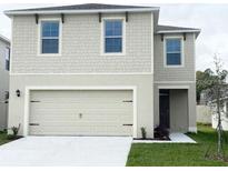 Charming two-story home with a neutral color scheme, a two-car garage, and a well-maintained front lawn at 167 Eagleview Loop, Davenport, FL 33837