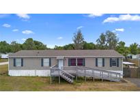 Charming single-story home with blue shutters, gray siding, and a ramp leading to the front door at 18806 Monroe Ave, Orlando, FL 32820