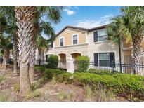 Charming townhome with a beautiful exterior, well-manicured landscaping, and mature palm trees at 1995 Majorca Dr, Kissimmee, FL 34747